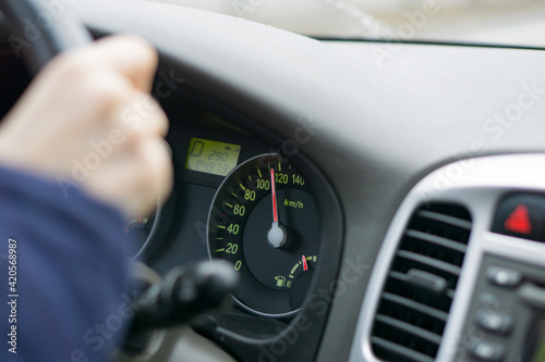 selective focus image of car interior. focus on analog speedometer - overspeeding concept. driver hands on steering wheel. High quality photo photo