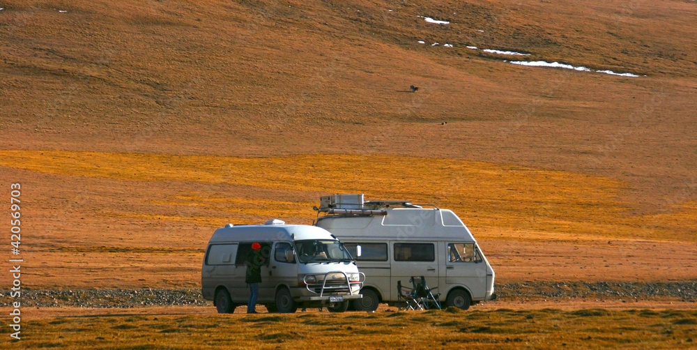 Kyrgyzstan - 10.09.2019: Cars in mountains. Mountain landscape view in Kyrgyzstan. Mountain panorama. Kyrgyzstan - 10.09.2019: Cars in mountains. Mountain landscape view in Kyrgyzstan. Mountain panorama.