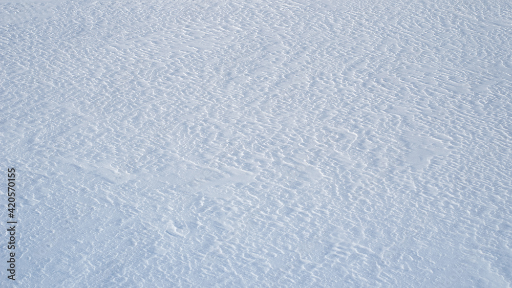 Natural snow texture, snow patterns from the wind, background.