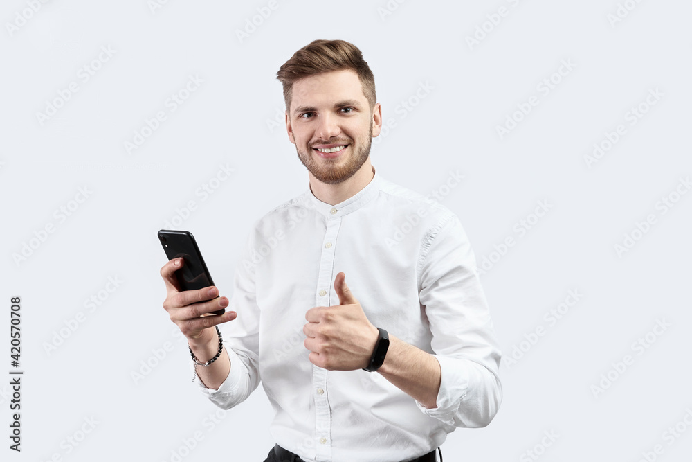 A man in white shirt using smartphone and excited A man in white shirt using smartphone and excited