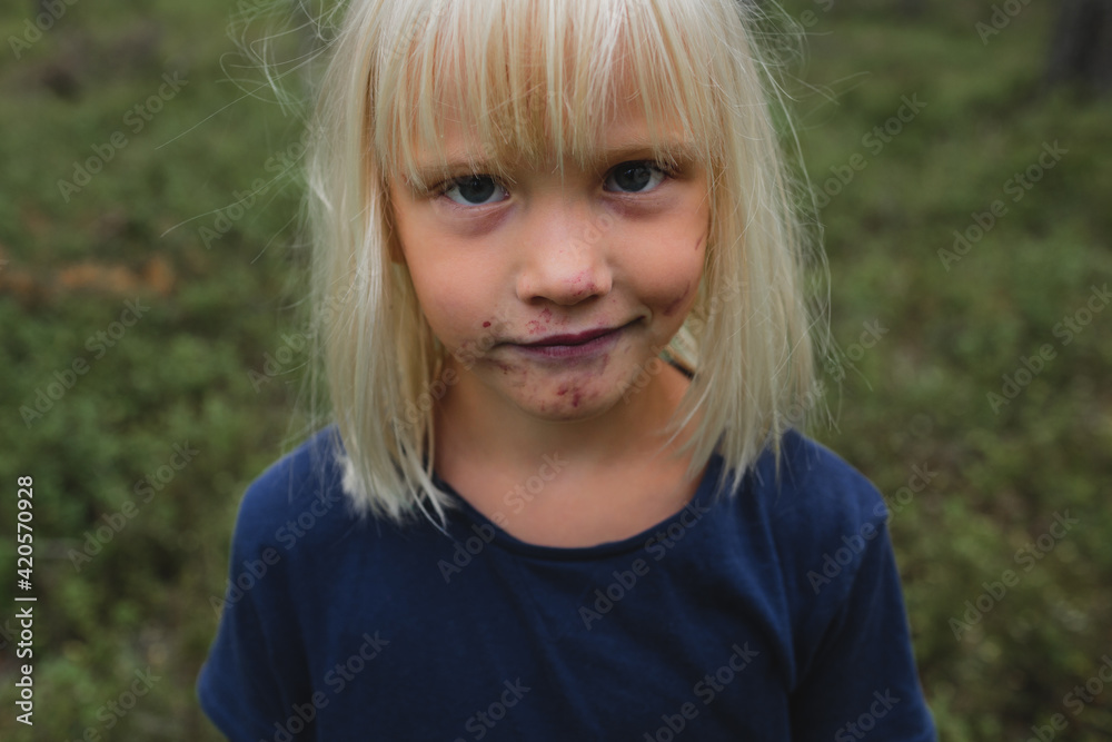 Child face stained with blueberries juice Child face stained with blueberries juice