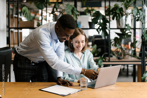 Black man helping colleague with project