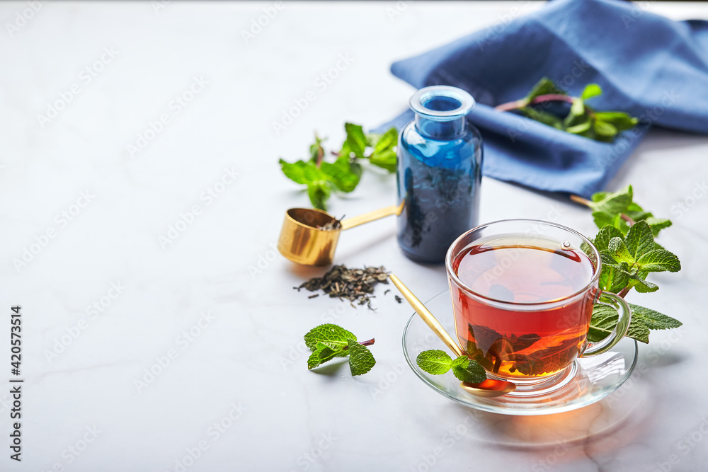 Black tea in glass transparent mug with mint leaves. Soothing tea, anti-stress Black tea in glass transparent mug with mint leaves. Soothing tea, anti-stress
