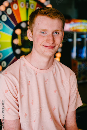 red headed teenage boy smiling at amusment park photo