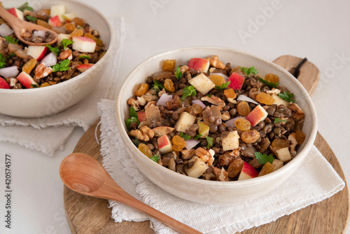 Bowl of vegetarian mixed salad, with lentils, apples, nuts and spices