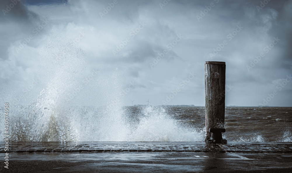 Waves at a harbour splashing against the shore with large amount of water 