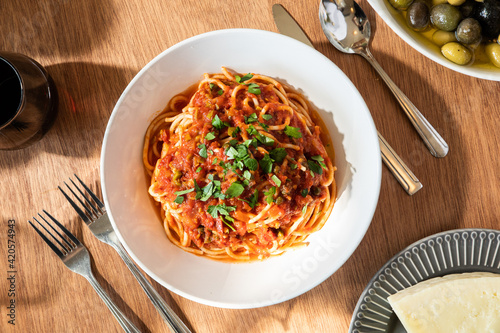 spaghetti puttanesca dish on table photo