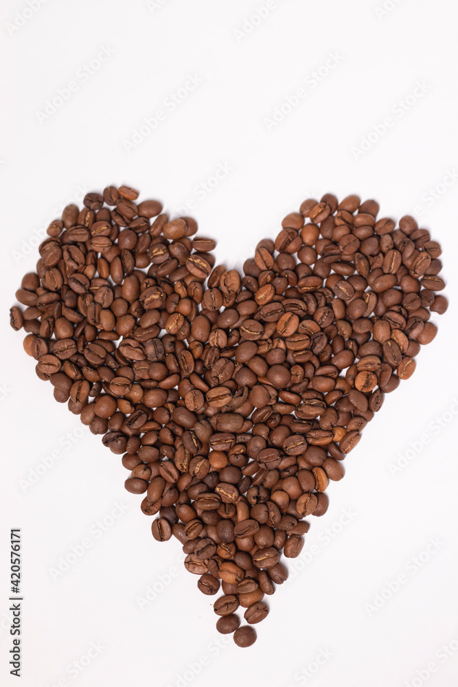 Freshly roasted coffee beans in shape of a heart isolated on white background. top view Freshly roasted coffee beans in shape of a heart isolated on white background. top view