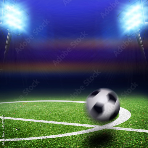 Fototapeta Naklejka Na Ścianę i Meble -  Center of a field with a ball in motion on a stadium with floodlights and flashes at night