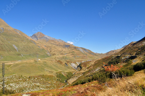 High snowy mountains with dry autumn grass and blue sky in France