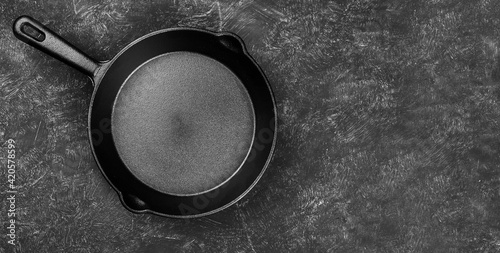 Rustic Cast-iron frying pan on black grunge background