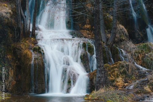 Waterfall in winter forest. 