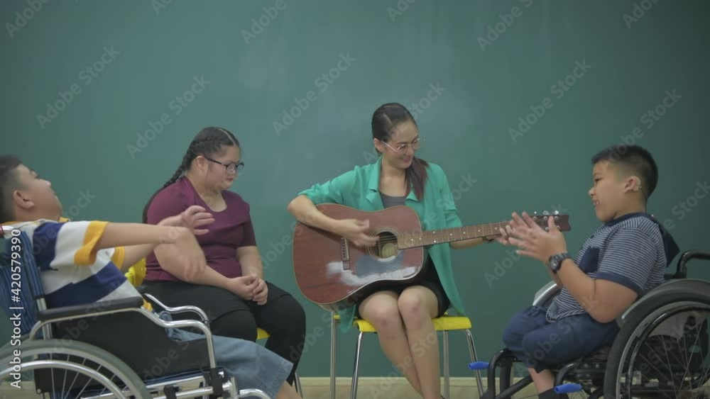 Education concept of 4k Resolution. The teacher is treating the minds of disabled children by playing music in the classroom. Education concept of 4k Resolution. The teacher is treating the minds of disabled children by playing music in the classroom.