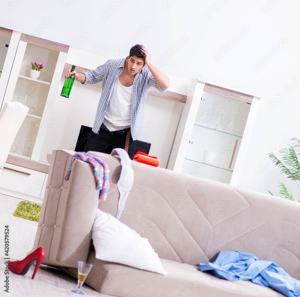 Man with mess at home after house party Man with mess at home after house party