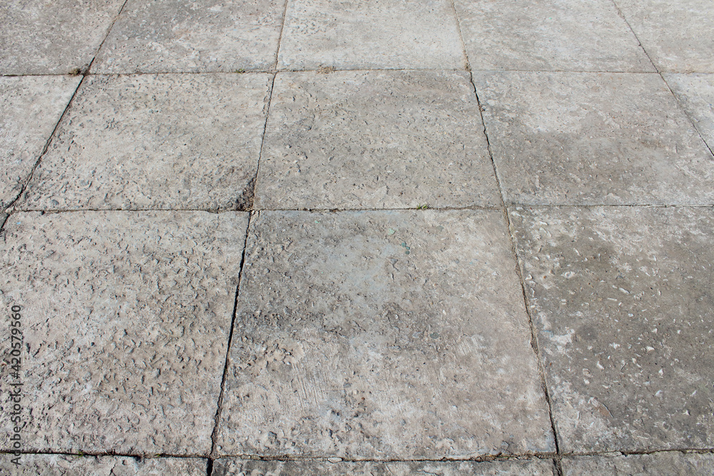 Fototapeta premium Old large square concrete paving slabs. Sidewalk. Perspective. Selective focus. Background. Texture.