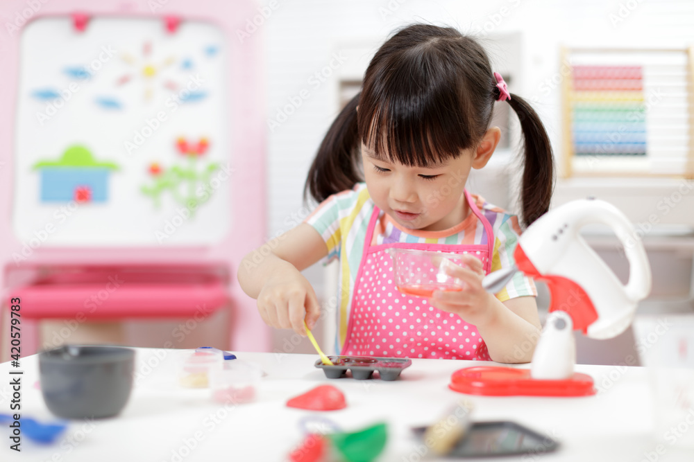 young  girl pretend play food preparing at home