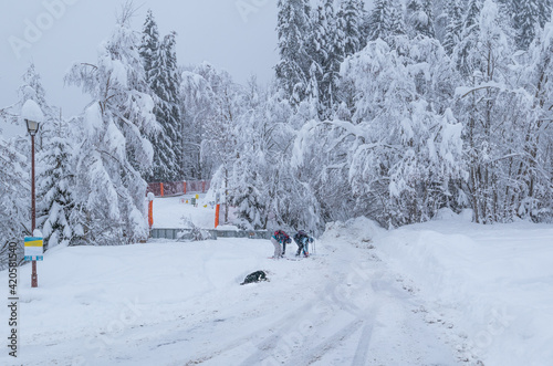 A pair of randonee skiers removing their skis after enjoying their ski down the mountain above the pretty French Alpine village of Les Contamines-Montjoie