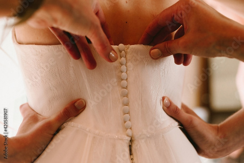 putting on the wedding dress photo