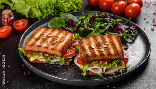 Delicious sandwich with crisp toast, ham, lettuce and tomatoes