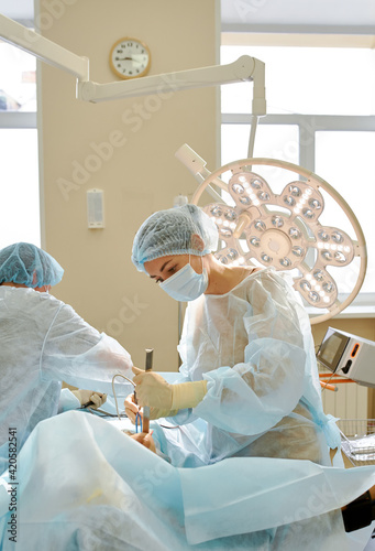 female doctor performs breast augmentation surgery for a woman photo