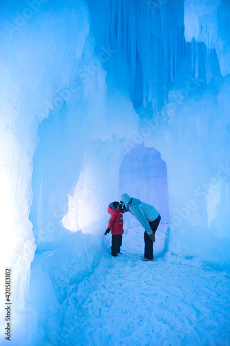 Mother and daughter kissing in an ice cave in the winter