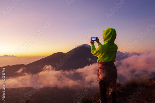 Woman photographs the landscape on the phone photo