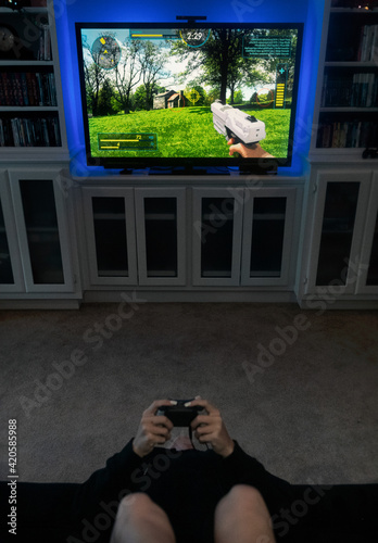 Girl Sits Upside Down To Play Shooter Video Game photo