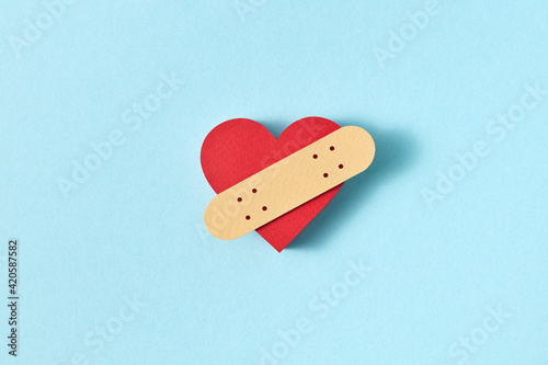 Papercraft figure of red heart with plaster strip.