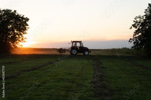 Tractor working on the field at sunset