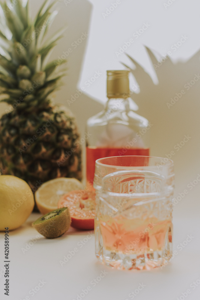 Cold refreshing drink with tropic citrus fruits slices glass on white toned background. Selective focus, copy space. Cold refreshing drink with tropic citrus fruits slices glass on white toned background. Selective focus, copy space.