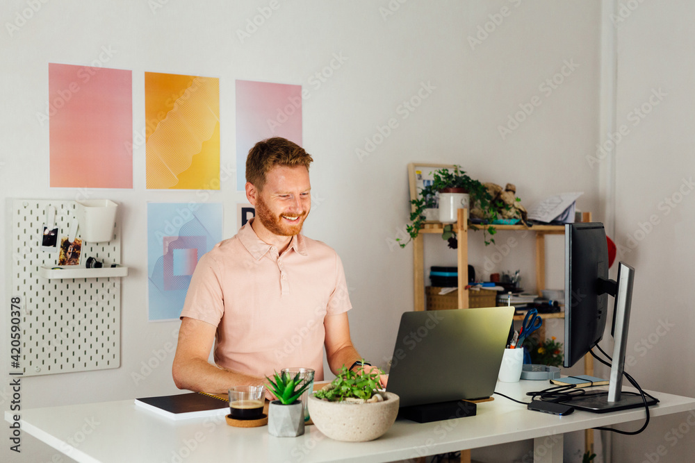 Man Standing At A Desk, Working On His Laptop Man Standing At A Desk, Working On His Laptop