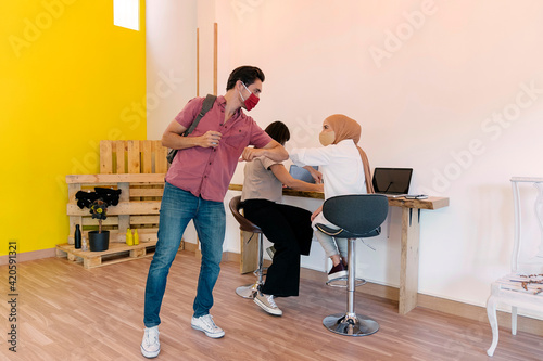 Coworkers Using Face Mask Elbow Bumping photo