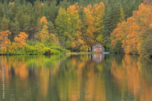 autumn on Loch farr. colourfull autumn colours  on a remote loch/lake in the Scottish highlands, reflection of colours on the water. photo