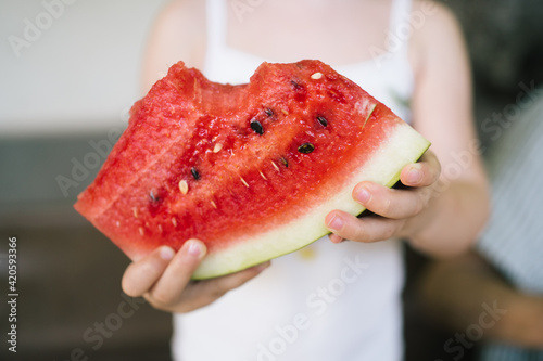 Slice of watermelon in hands of a child photo