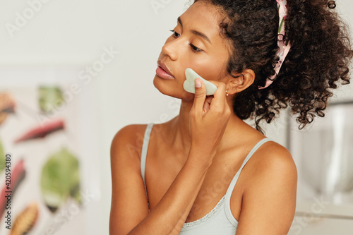 Woman using gua sha stone photo