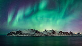 Blue and green glowing northern lights over norwegian winter landscape