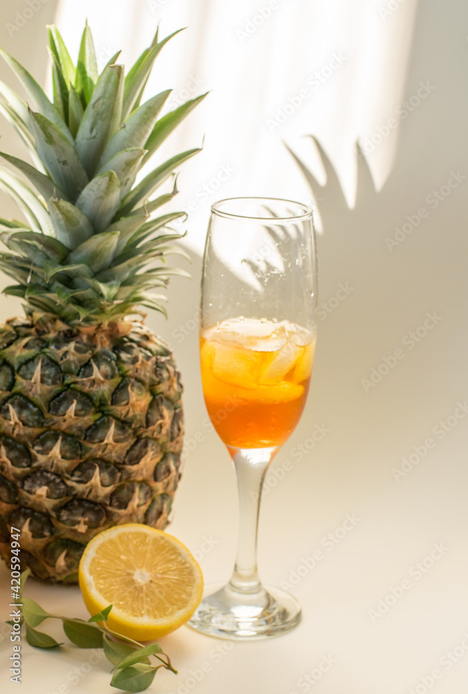 Cold refreshing drink with lemon orange slices by the glass on white background on directly sunlight with shadows Cold refreshing drink with lemon orange slices by the glass on white background on directly sunlight with shadows