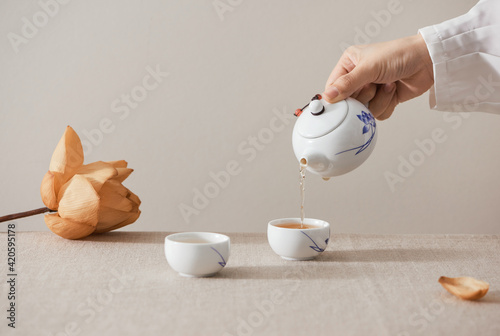 person pours tea into cup isolated on white for your text photo