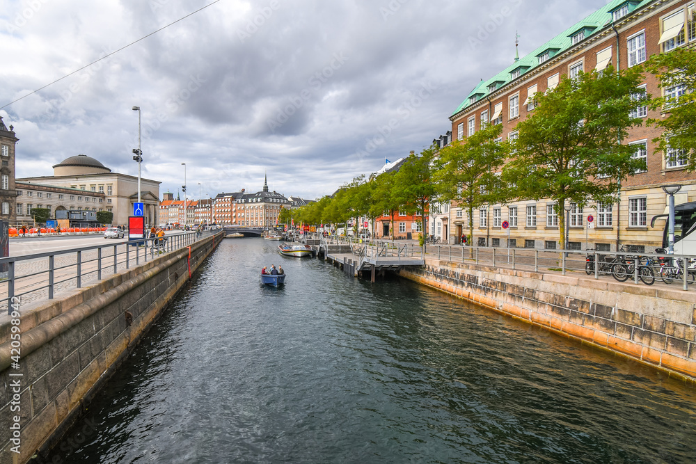 A group of people cruise a river canal in the urban center of Copenhagen, Denmark.
