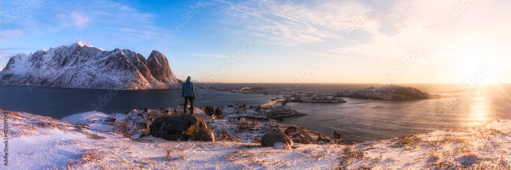 Man standing in front of arctic sunrise panorama