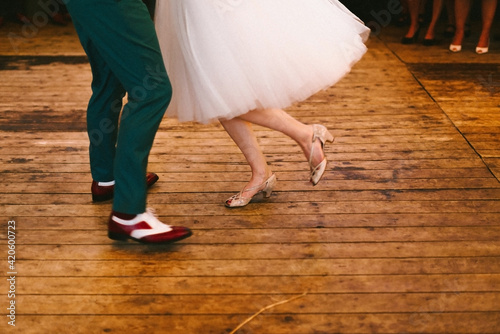 close up of rock and roll couple dancing on a wooden floor