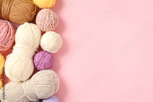 Fototapeta Soft colorful woolen yarns on pink background, flat lay