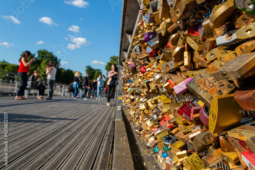 Wall of love locks in bridge with people as background