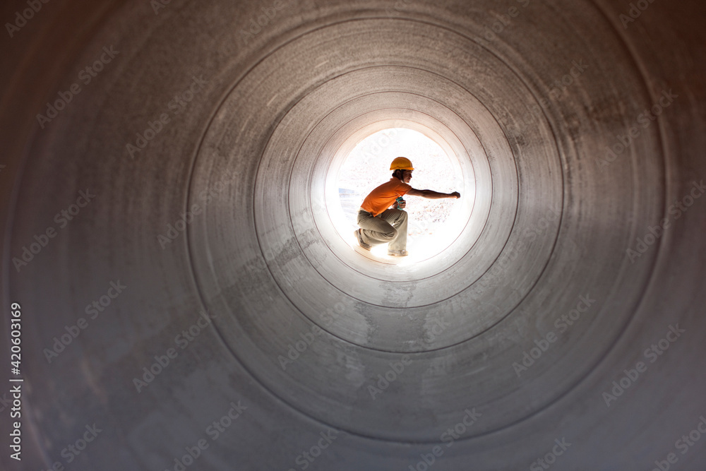 © Hugh Sitton/Stocksy - Construction worker inspecting water pipeline. India.