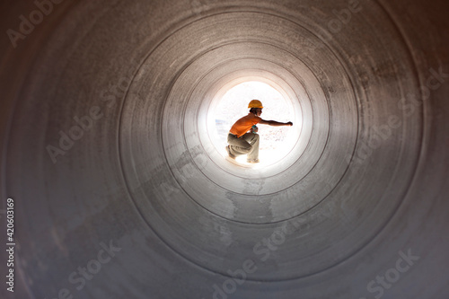 Construction worker inspecting water pipeline. India. photo
