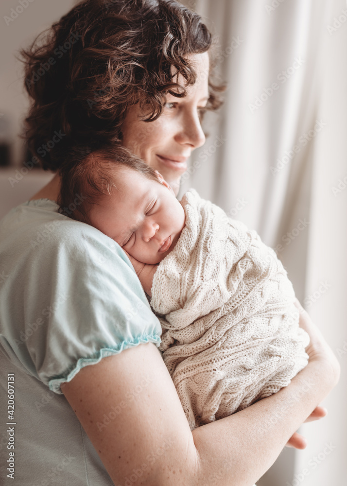 Loving mother with her sleeping baby on her shoulder Loving mother with her sleeping baby on her shoulder
