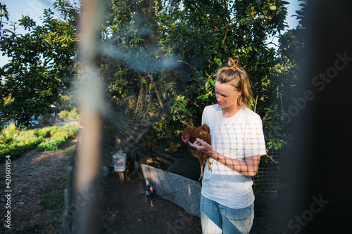 Woman spending time with laying chickens on farm