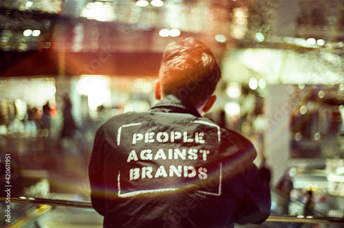 Anonymous man wearing a jacket written - people against brands