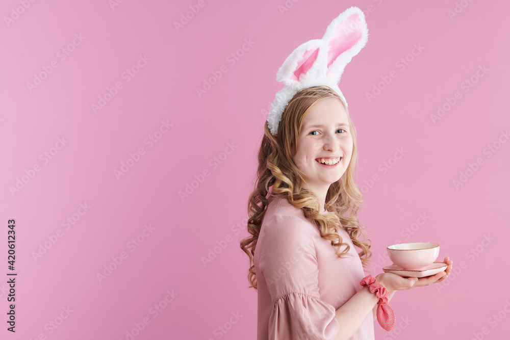 Portrait of happy modern girl with long wavy blond hair on pink