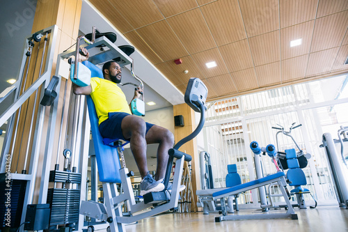 Man in yellow T-shirt on exercise machine photo